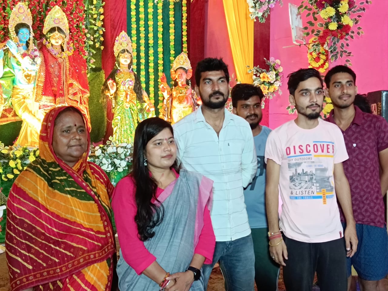 A vibrant gathering at a traditional religious festival, where community members come together in prayer and celebration before beautifully decorated deities.